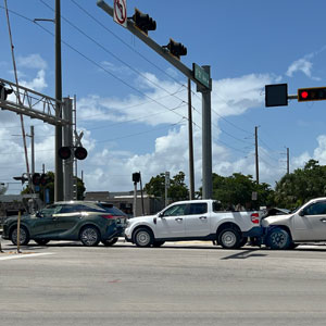 Three cars collided at a red signal on the road, depicting a multi-vehicle accident scene.